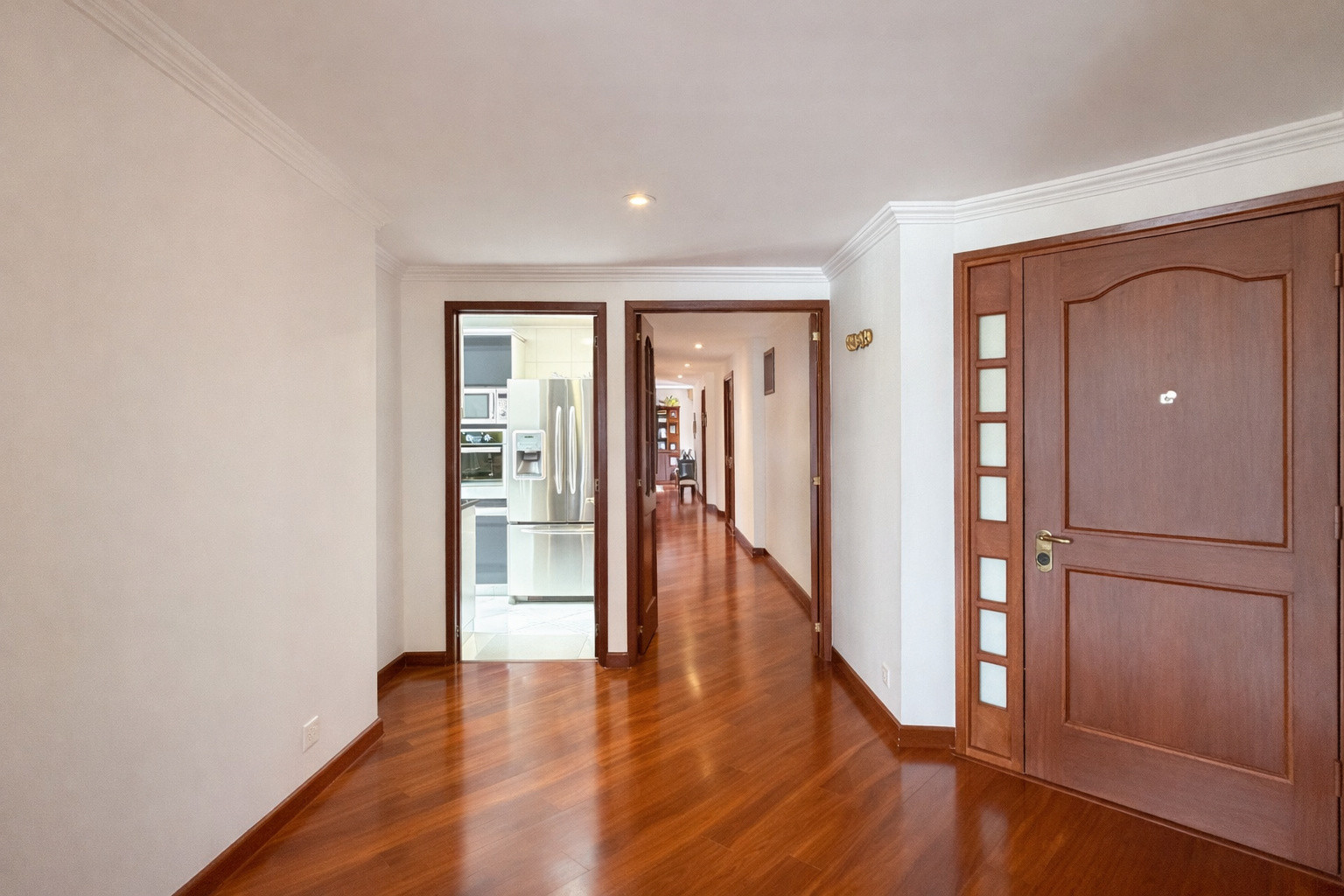 Pasillo residencial con puerta de madera
